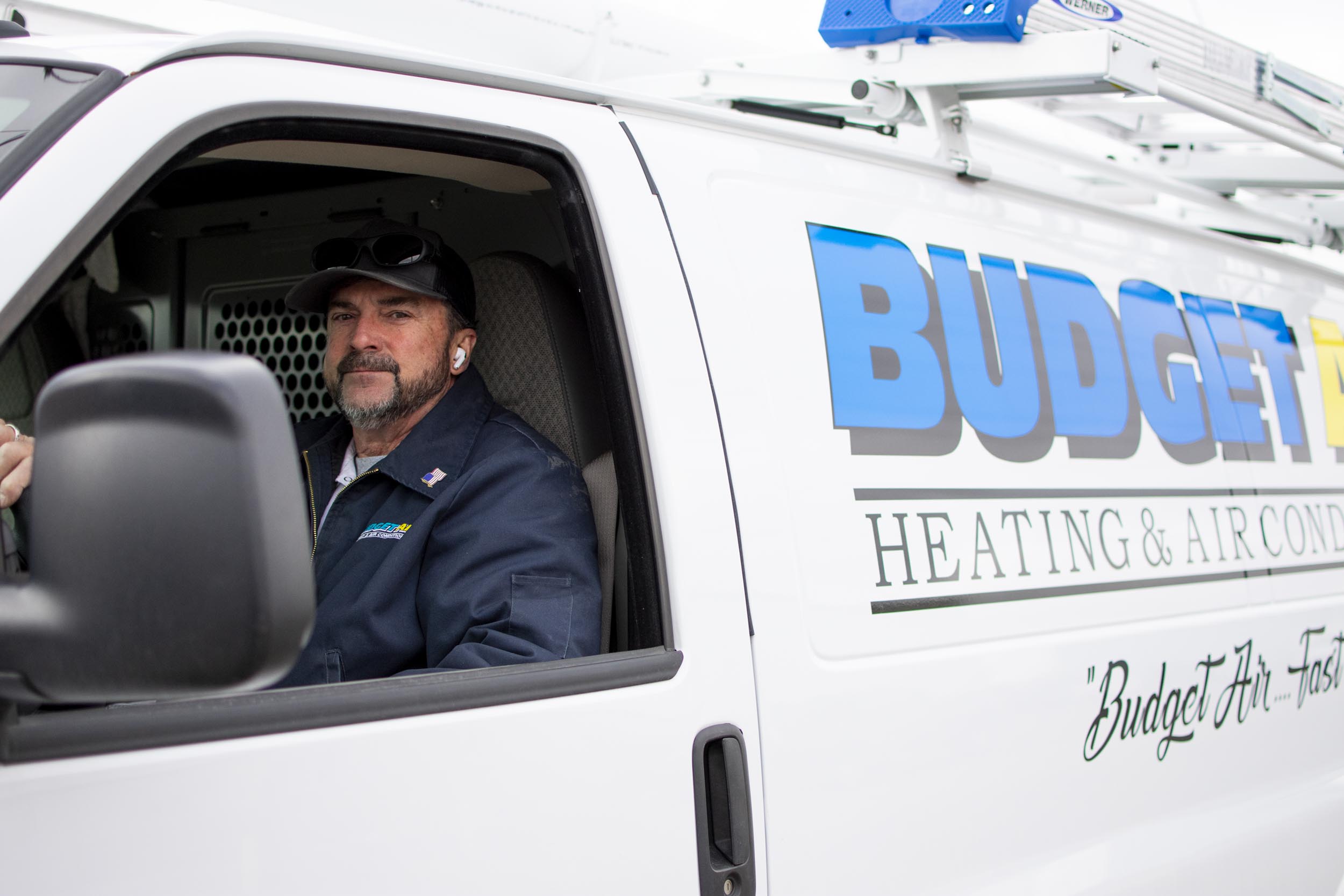 HVAC technician driving Budget Heating & Air Conditioning van.