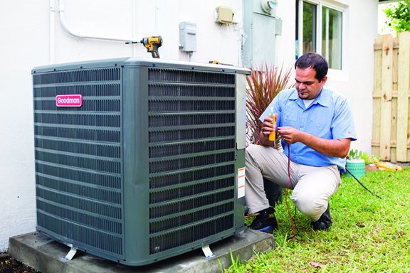 HVAC technician servicing air conditioning unit.