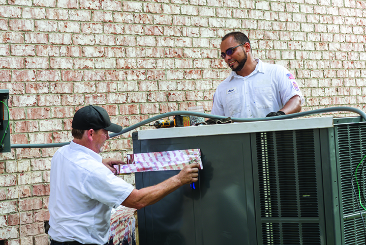 Two Budget Air HVAC technician repairing air conditioning unit.